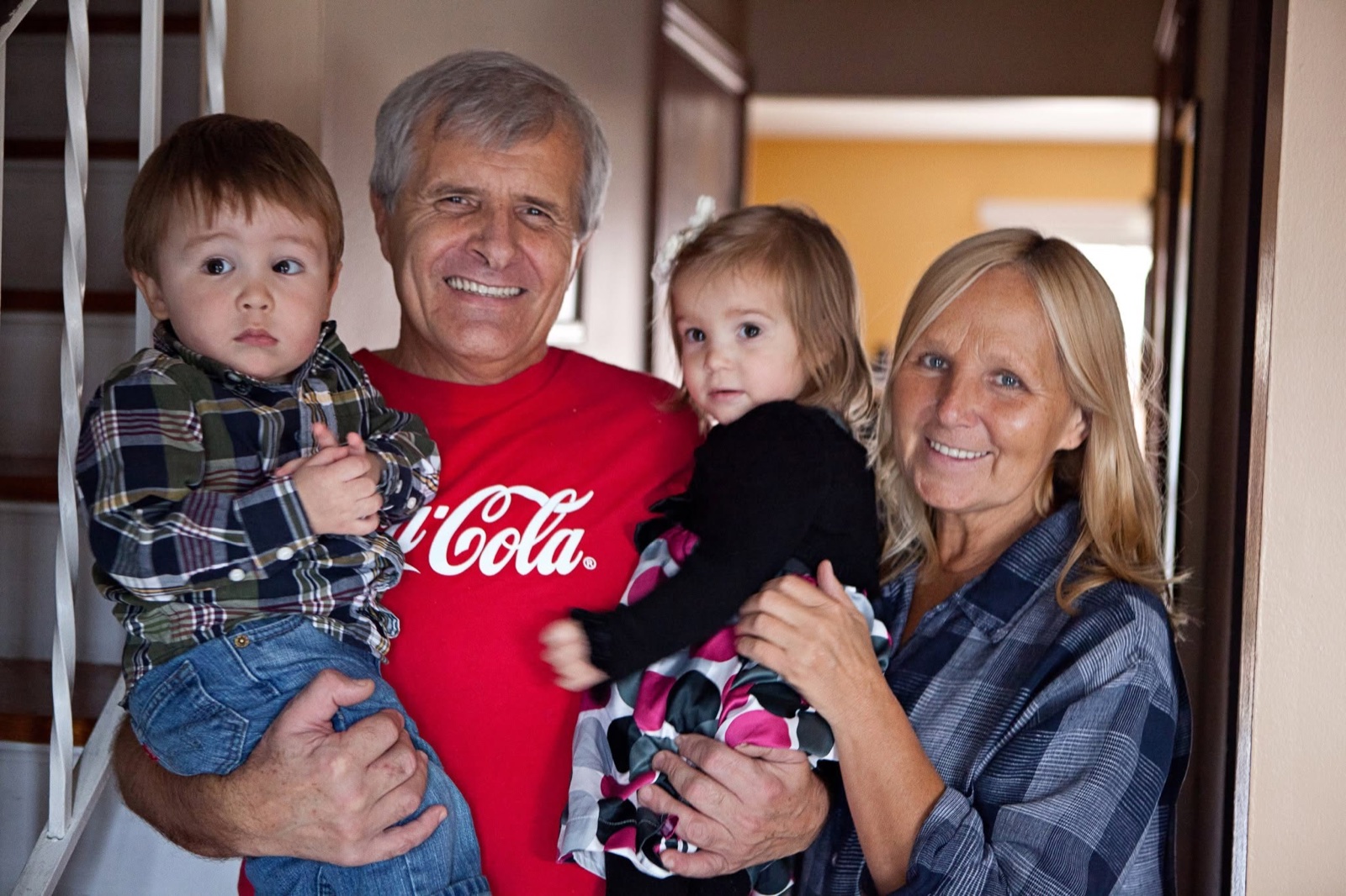 Viktor Prokhnevskiy standing with his wife and two grandchildren